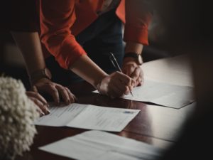 paperwork probate man and woman over table signing documents